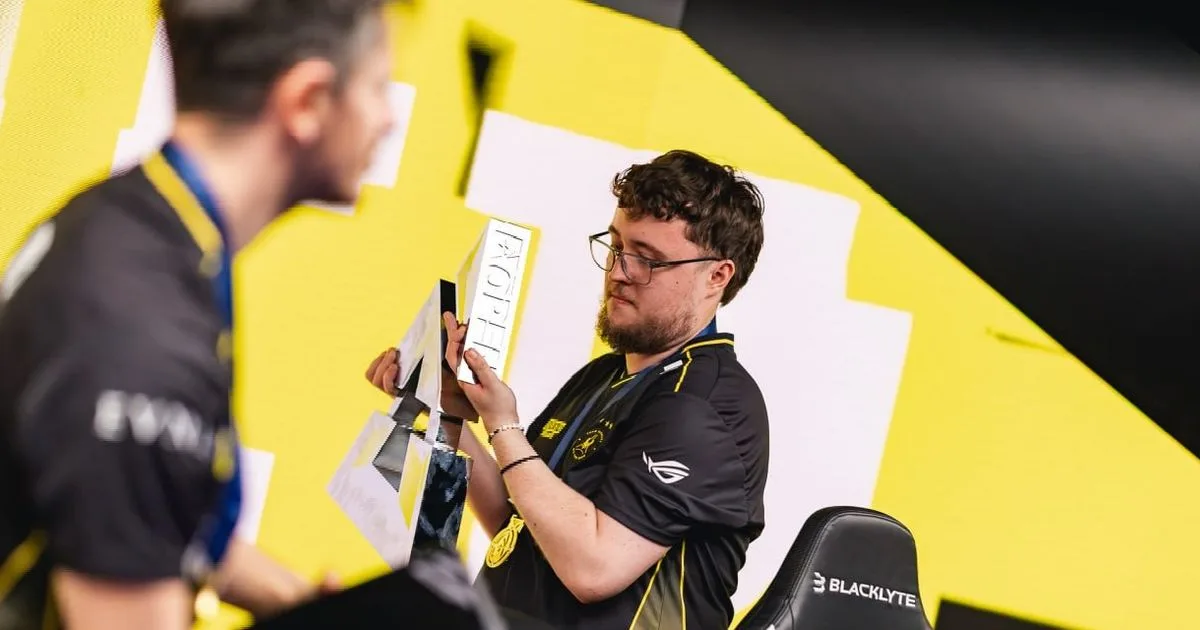 Игрок Vitality с наградой на фоне жёлтого баннера